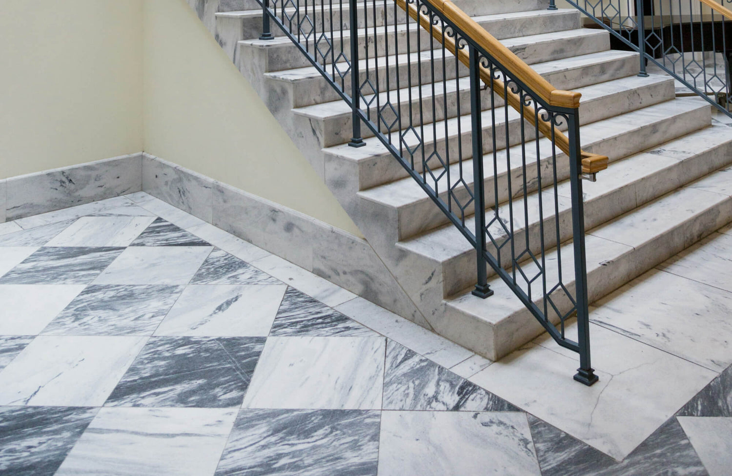 Elegant stairwell featuring a classic black and white marble checkered tile floor, adding a timeless and sophisticated touch to the space.