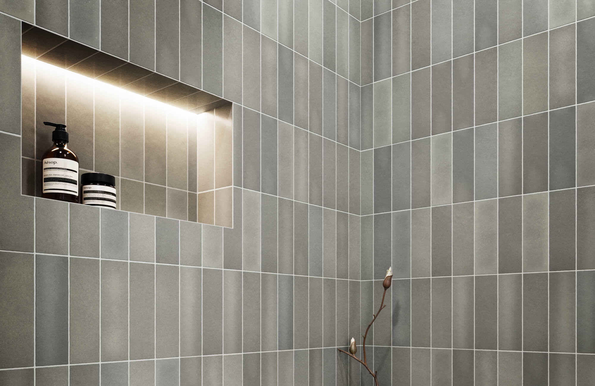 Modern shower featuring matte subway tiles in soft gray tones, highlighted by a recessed shelf with warm lighting for a sleek, functional design