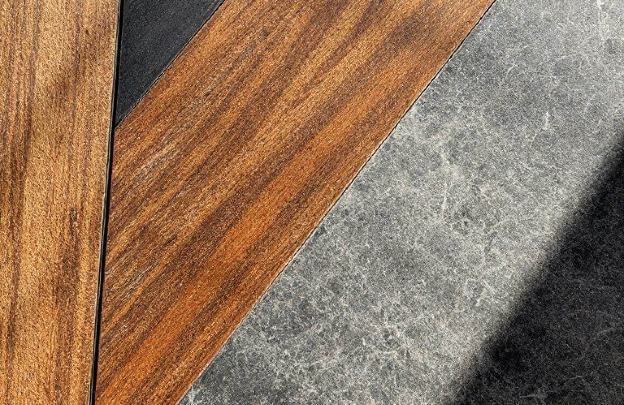 Close-up of textured brown wood and grey concrete planks arranged side by side, showcasing contrast.