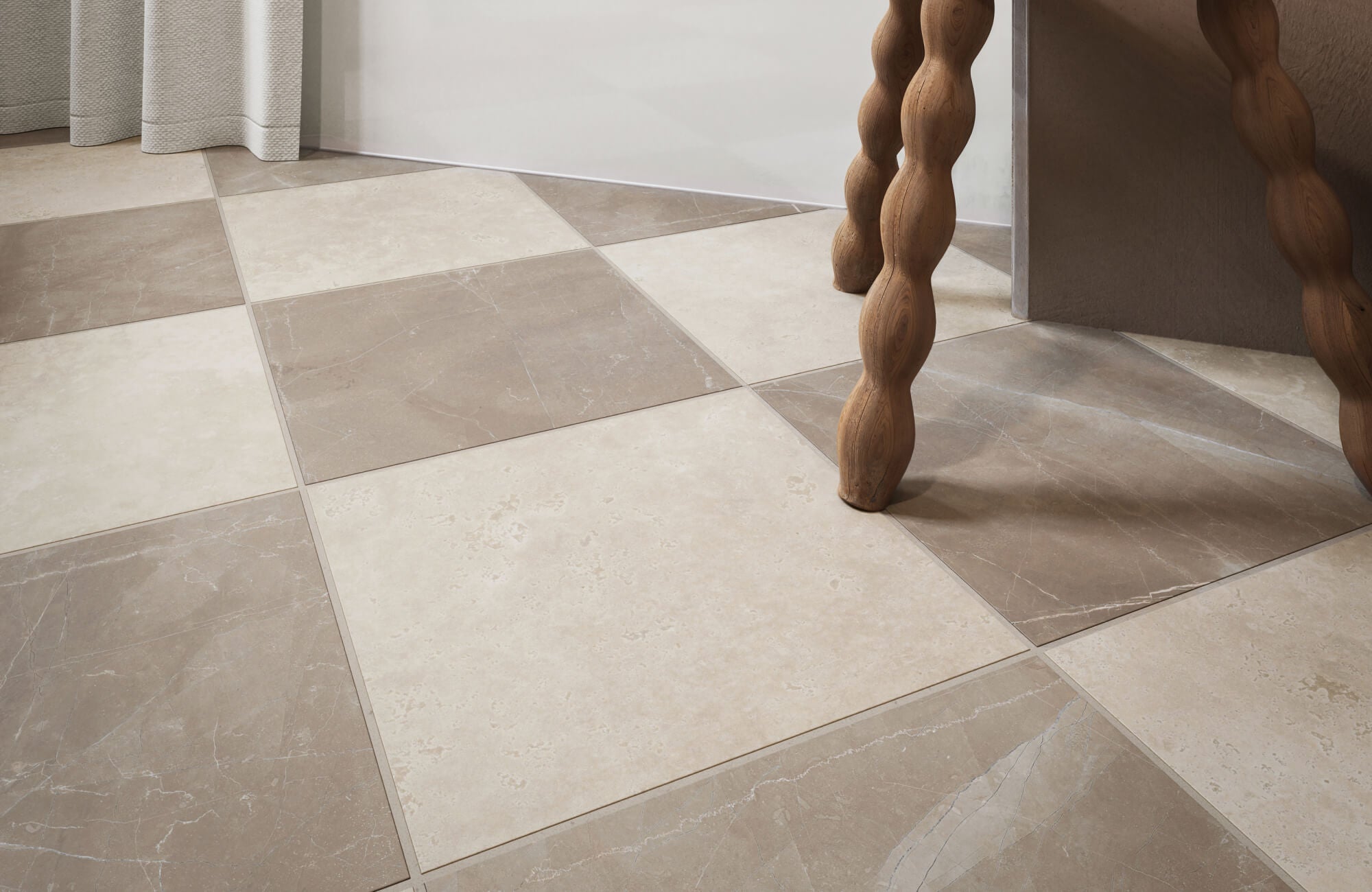 Elegant checkerboard tile flooring with large square tiles in soft beige and muted taupe tones, creating a sophisticated, natural stone look that pairs beautifully with wood accents. 