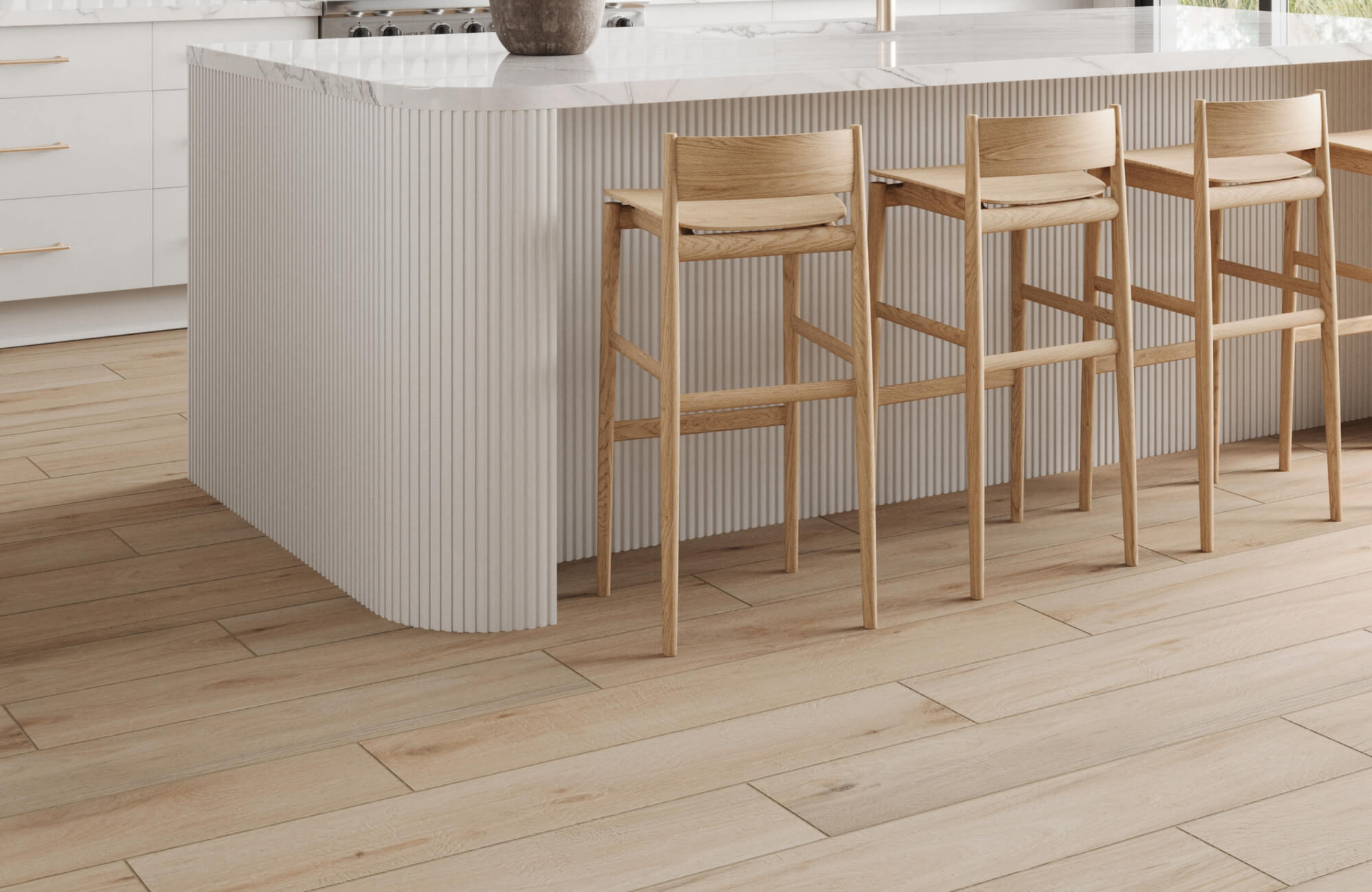 Light wood-look tiles with subtle grain details enhance a modern kitchen, paired with natural wood bar stools and a sleek marble island. 