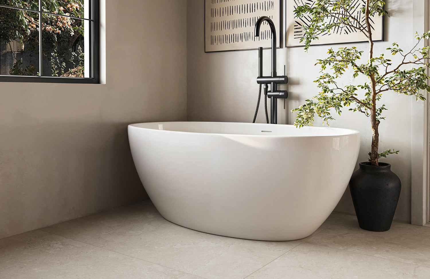 Minimalist bathroom with a sleek freestanding white tub, black matte fixtures, and neutral tones, creating a serene and spa-like retreat.