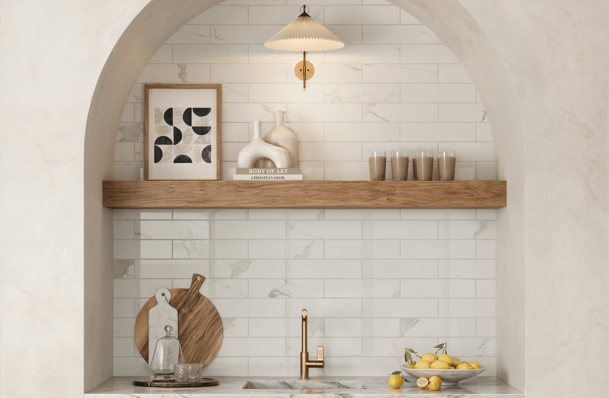 White subway tiles line the arched kitchen nook, providing a clean, timeless backdrop that contrasts with a natural wood shelf and brass faucet. 