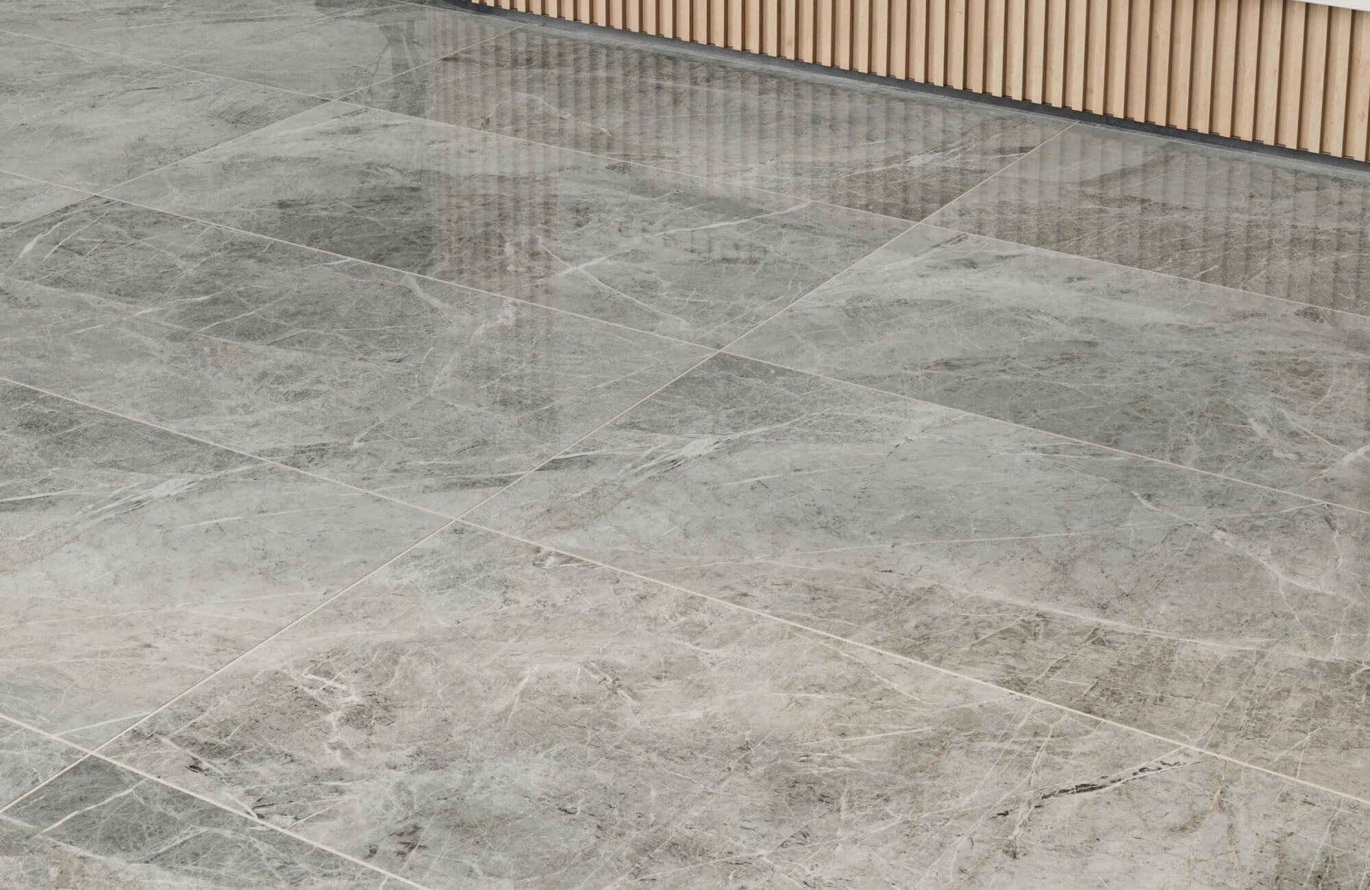 Smooth gray marble tiles with subtle white veining create an elegant flooring, enhancing a modern wooden interior.