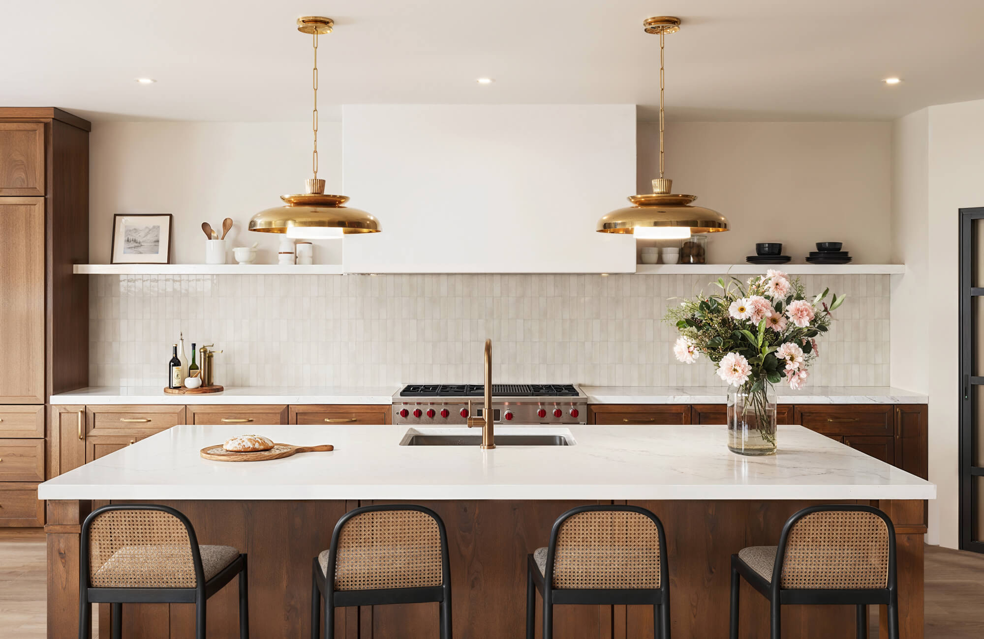 Modern kitchen with warm wood cabinetry, brass pendant lighting, and a subway tile backsplash for timeless elegance.