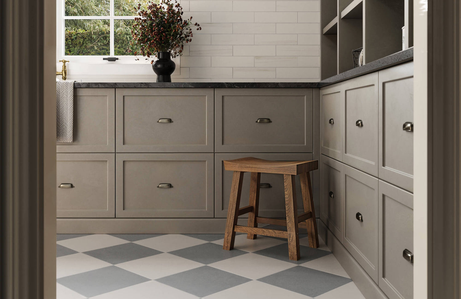 Charming laundry room featuring soft gray cabinetry, a wooden stool, and blue-and-white checkerboard flooring for a clean, classic design.