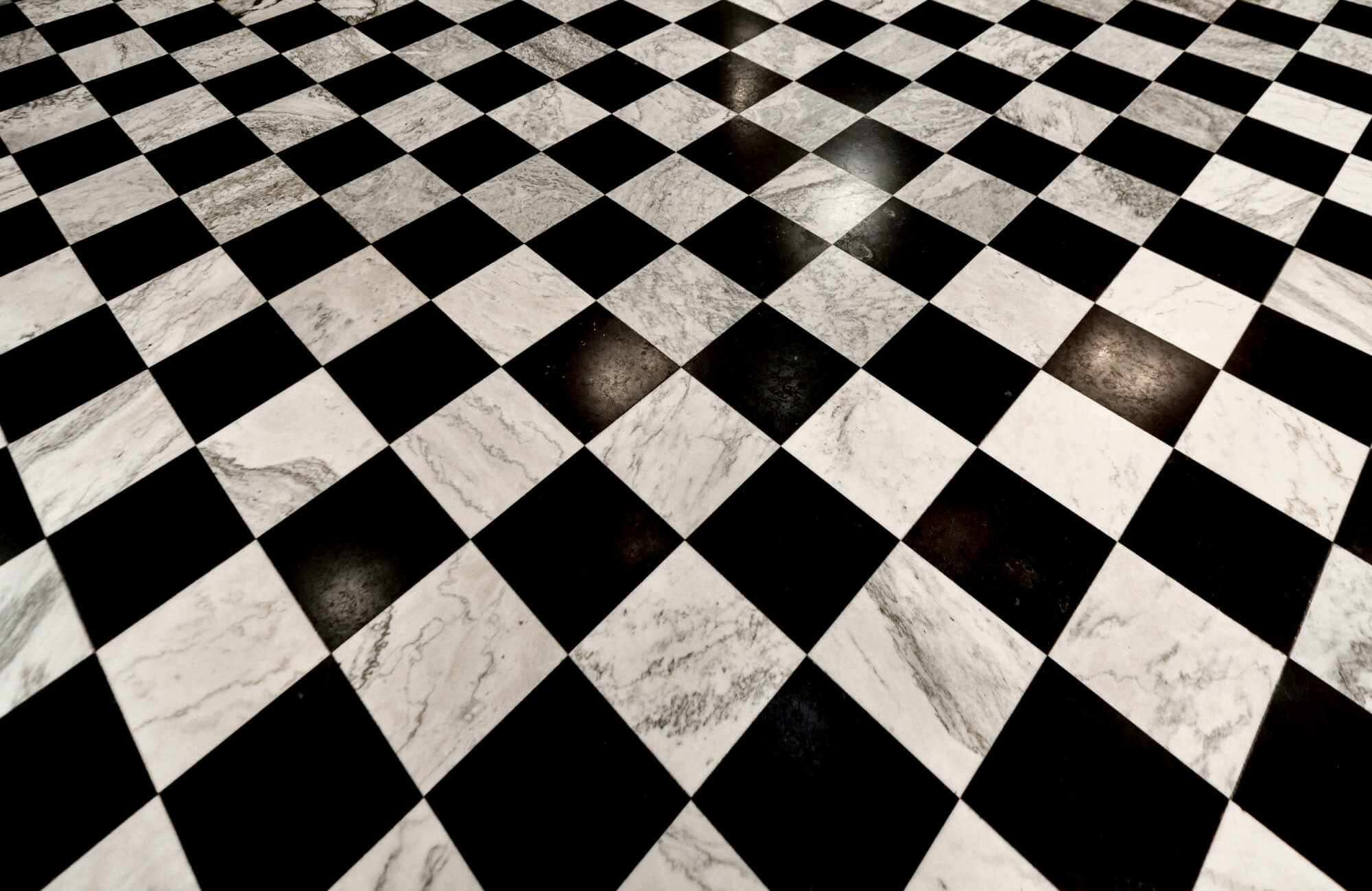 Classic black and white chequered floor tiles in a large format, exuding a timeless and elegant appeal for any interior space