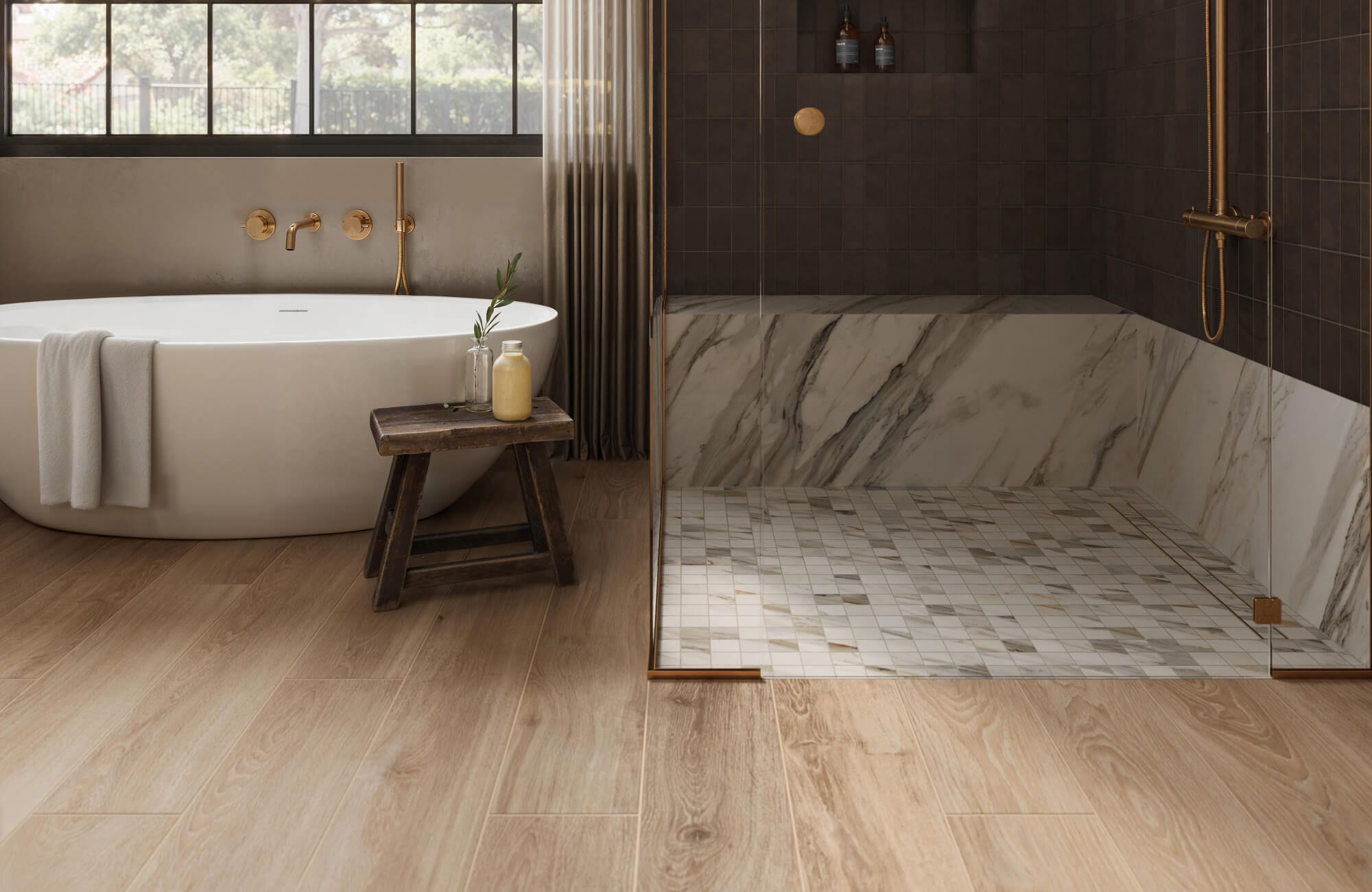 A luxurious bathroom featuring wood-look tiles on the floor, a freestanding white tub, and a marble-tiled walk-in shower with gold fixtures.