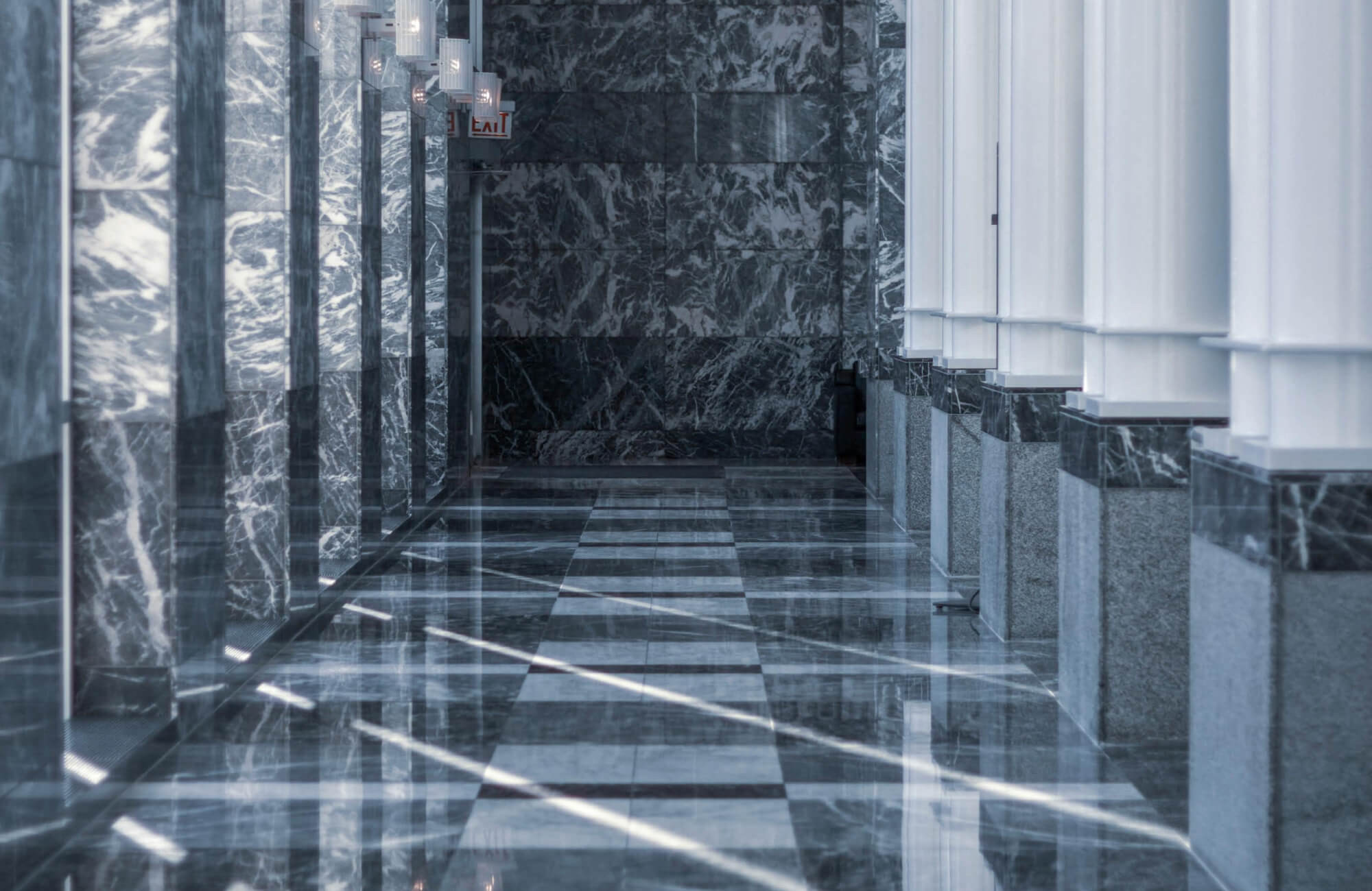 Sleek corridor with polished grey marble tiles, featuring intricate white veining, creating a luxurious ambiance