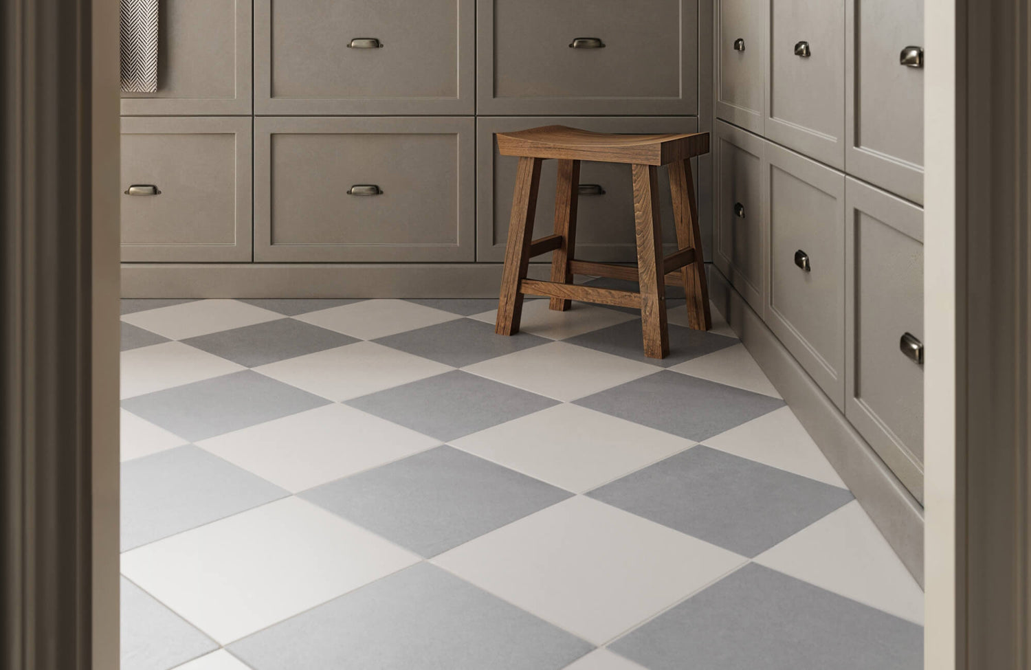 Modern kitchen with sleek gray cabinetry, featuring a stool on gray and white checkerboard tile flooring for a stylish touch