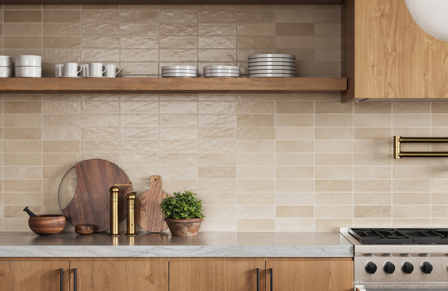 Beige subway tiles create a warm, textured backdrop in this inviting kitchen, paired with natural wood cabinetry and marble countertops.