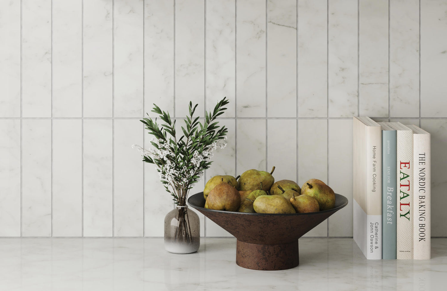 Elegant white marble look tile backdrop in a bright kitchen, featuring a rustic fruit bowl and fresh greenery next to modern cookbooks