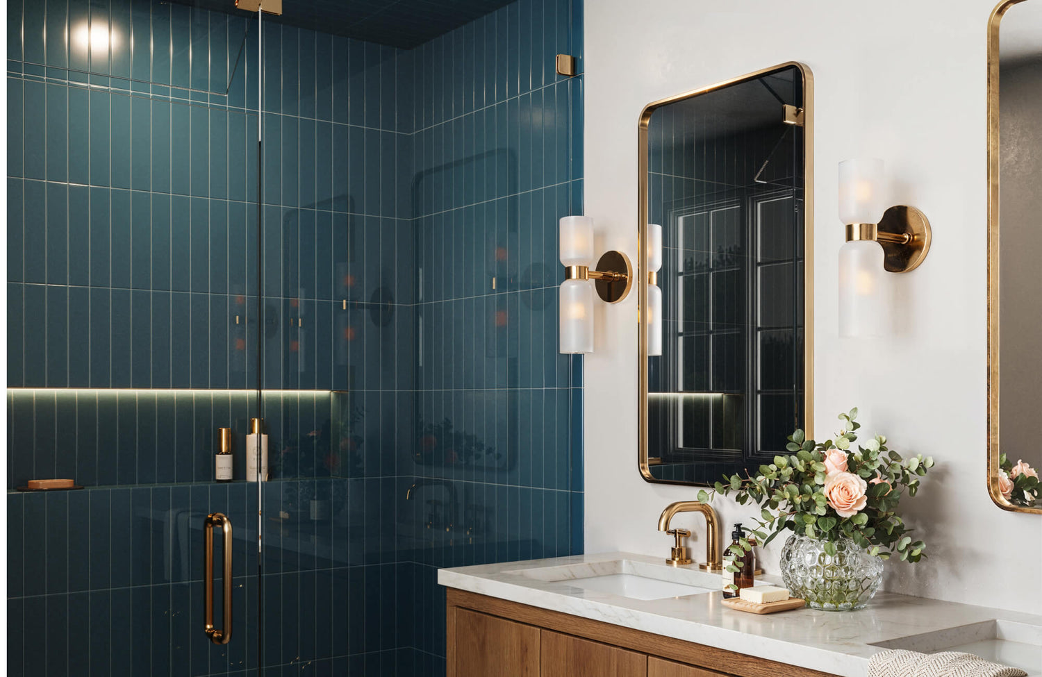 Luxurious bathroom featuring glossy blue vertical subway tiles, brass fixtures, and a marble countertop, exuding modern elegance.