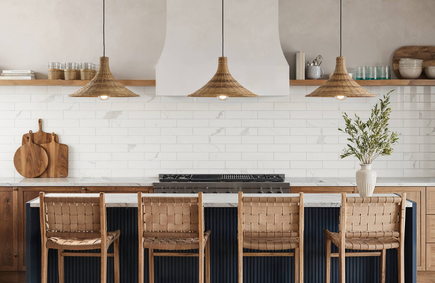 Textured white subway tiles create a bright, airy kitchen atmosphere, complemented by rustic woven lights and wooden accents