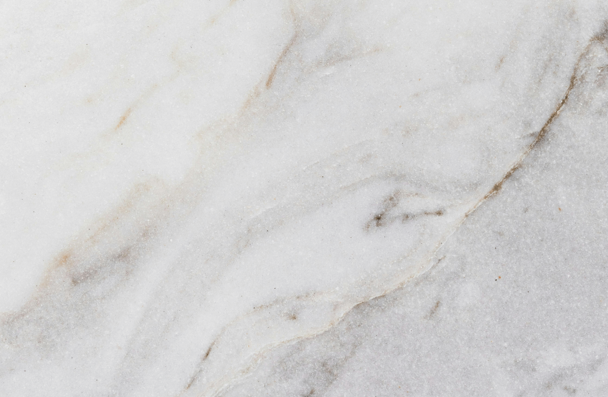 Luxurious marble surface featuring soft gray and white swirls with delicate veining, exuding timeless elegance and natural charm.