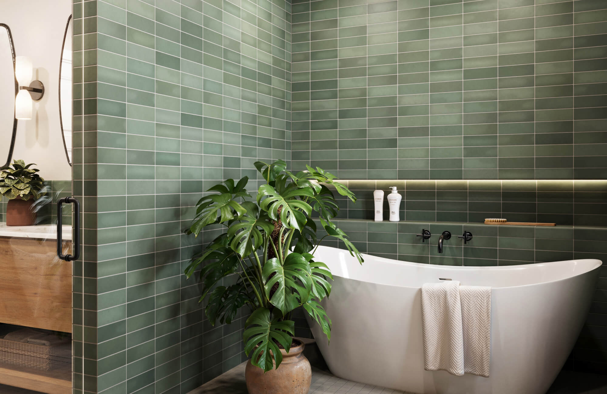 Modern bathroom featuring sleek green subway tiles, a white freestanding tub, and lush greenery for a refreshing, natural aesthetic.