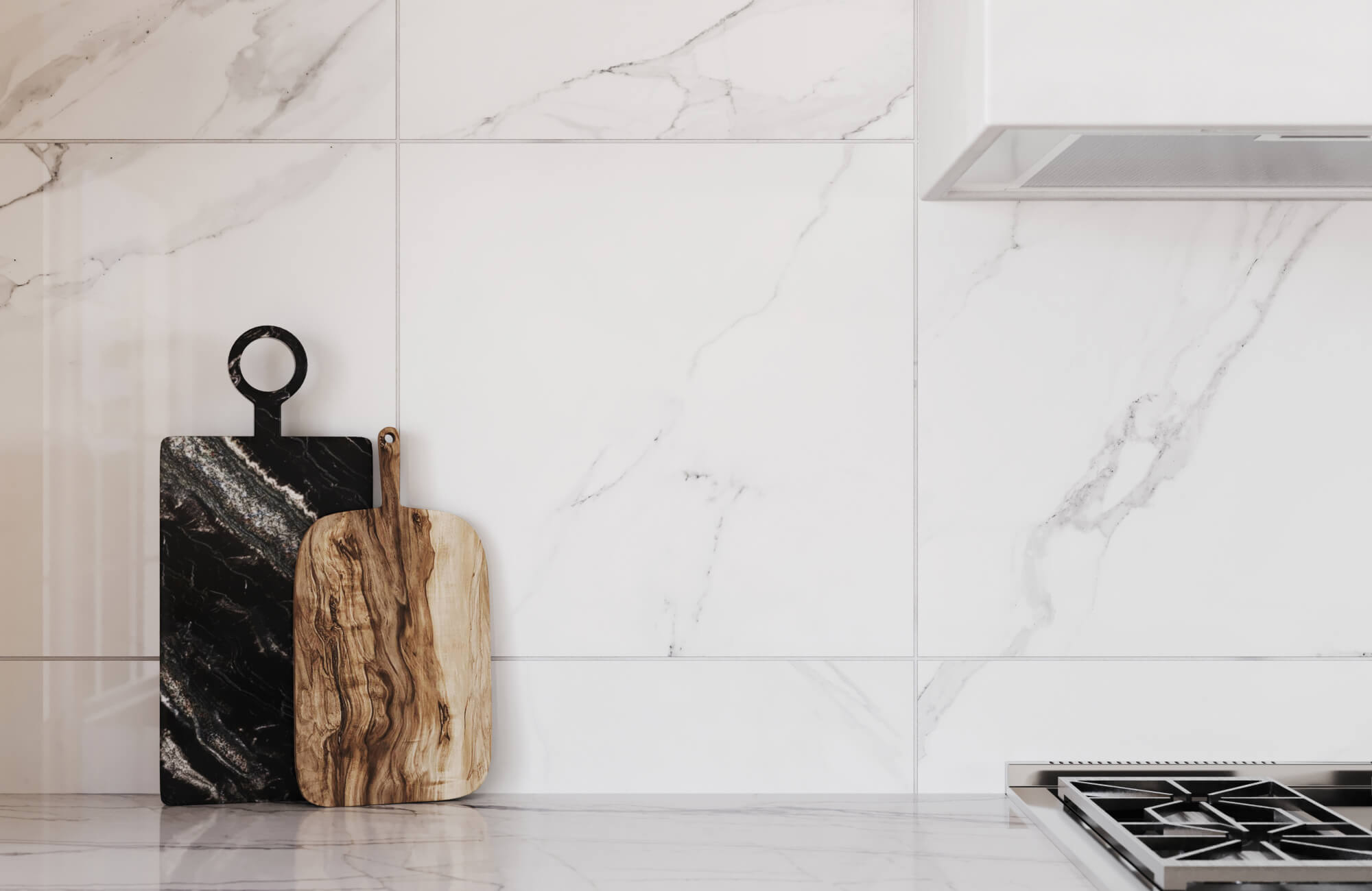 Modern kitchen with sleek white marble-effect tiles as a backsplash, accented by two stylish cutting boards in black and natural wood tones.