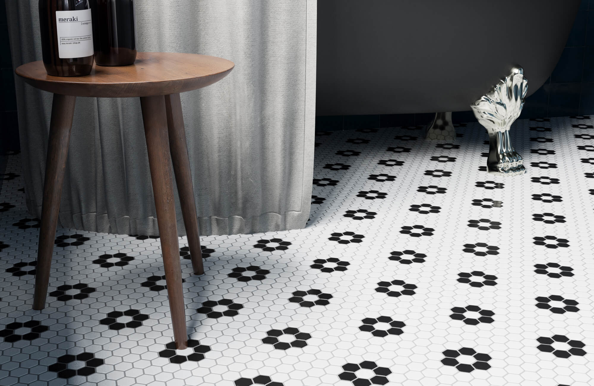 Hexagonal white tiles with black floral accents create a charming retro-inspired bathroom floor, complementing the clawfoot tub and wooden table. 