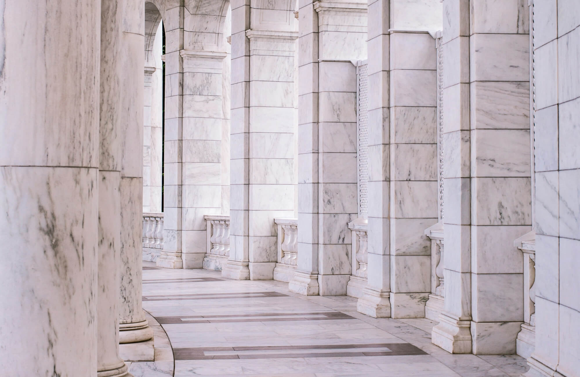 Ornate Renaissance architecture with a grand staircase and marble statues adorn this historic facade, featuring intricate stone carvings and a central arched niche.