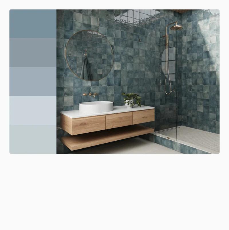 Rustic blue bathroom tiles add depth and tranquility to a modern bathroom, featuring a floating wooden vanity and glass shower enclosure