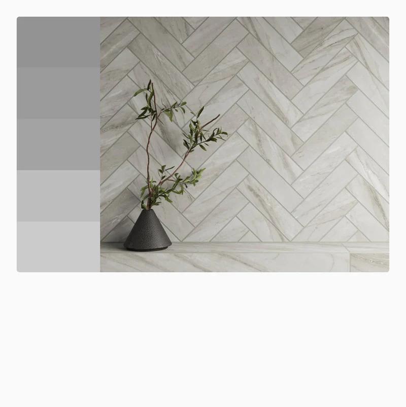 Light gray herringbone tiles bring a subtle elegance to this space, paired with a minimalist vase for a clean, modern look