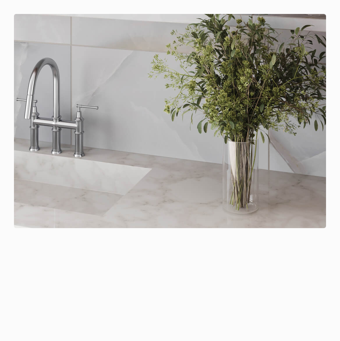 Elegant kitchen setup with light grey tiles, a sleek chrome faucet, and a marble countertop, accented by a vase of lush green foliage