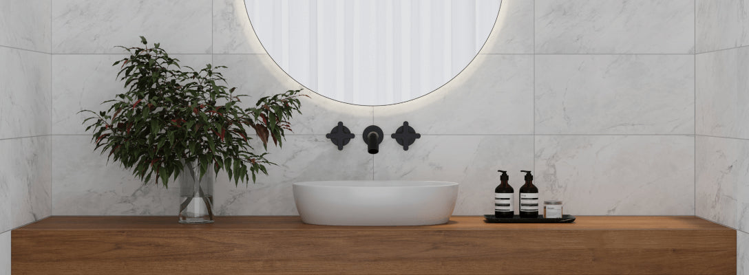 Modern bathroom with large chalk-toned matte wall tiles, a black-framed mirror, and a marble accent backsplash for understated elegance.