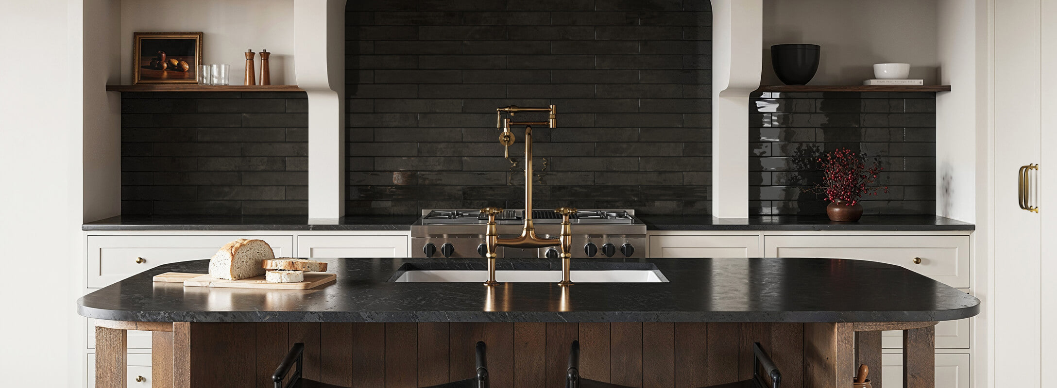 A modern kitchen featuring a striking black backsplash made of elongated subway tiles, contrasting with the brass fixtures and dark countertops for a bold, elegant design