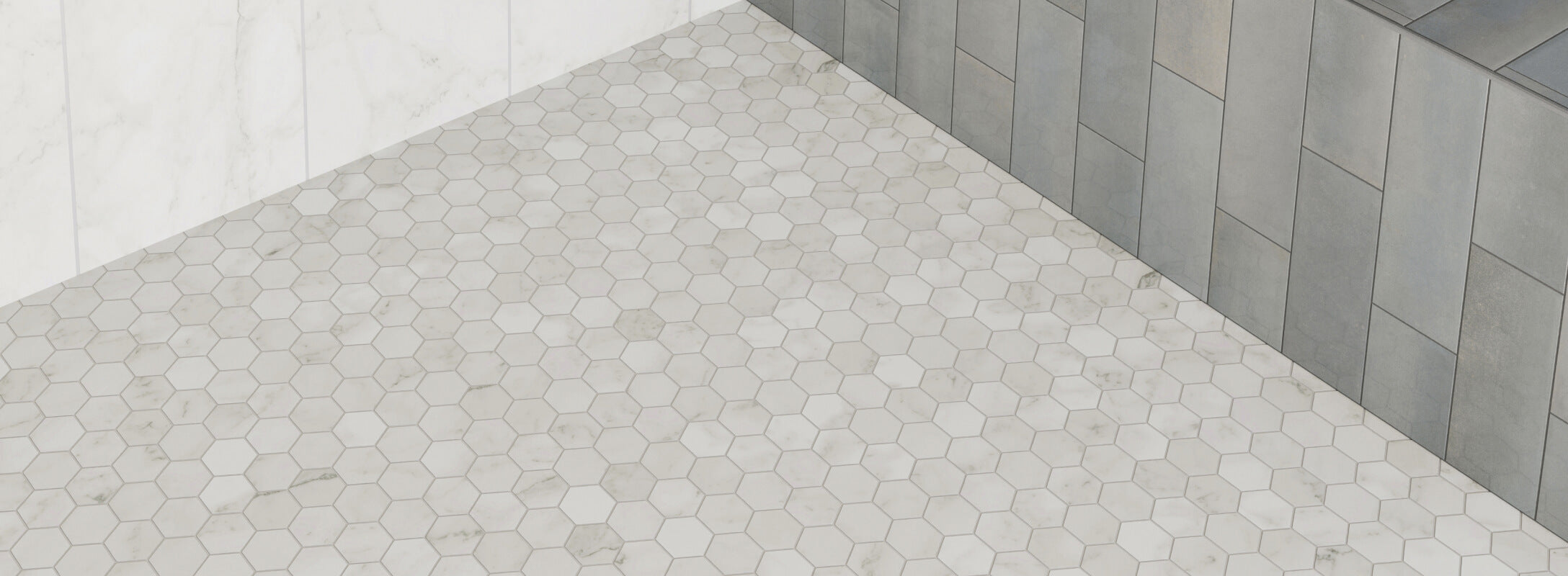 Elegant shower featuring light grey hexagonal mosaic tiles on the floor and varying shades of gray tiles on the walls, creating a cohesive and sophisticated design