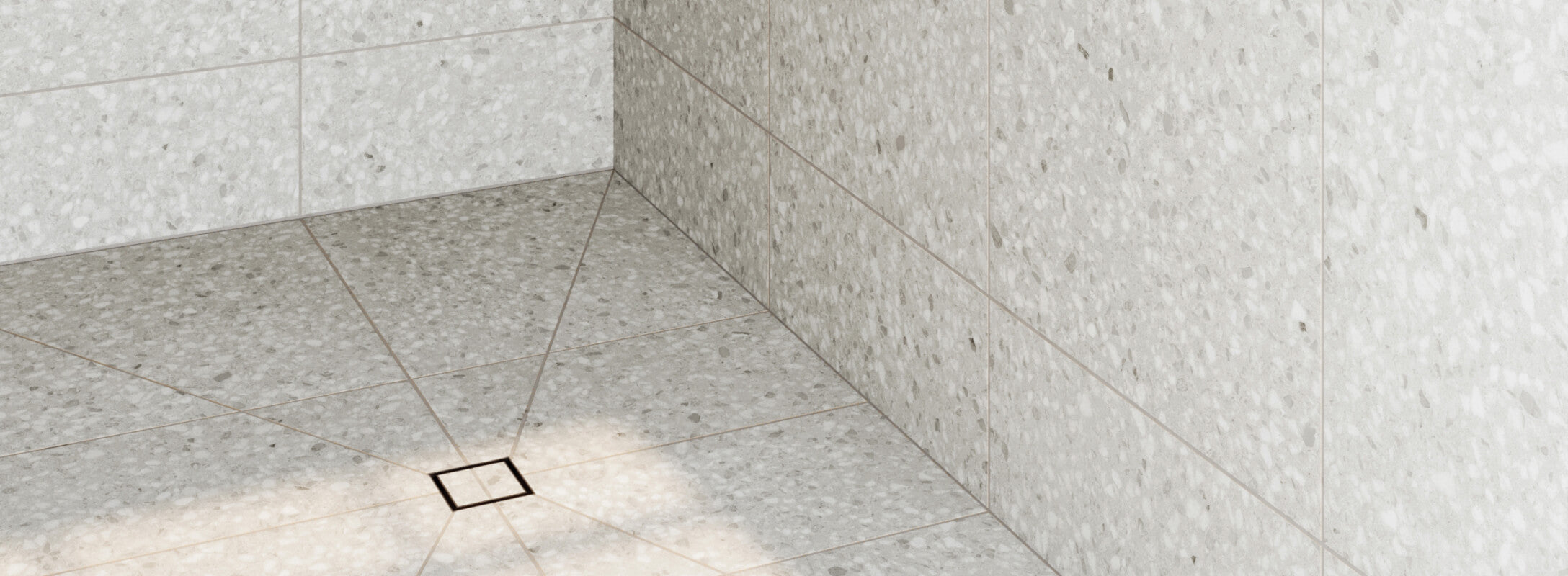 Modern shower with light grey terrazzo look tiles on the floor and walls, creating a cohesive and elegant design