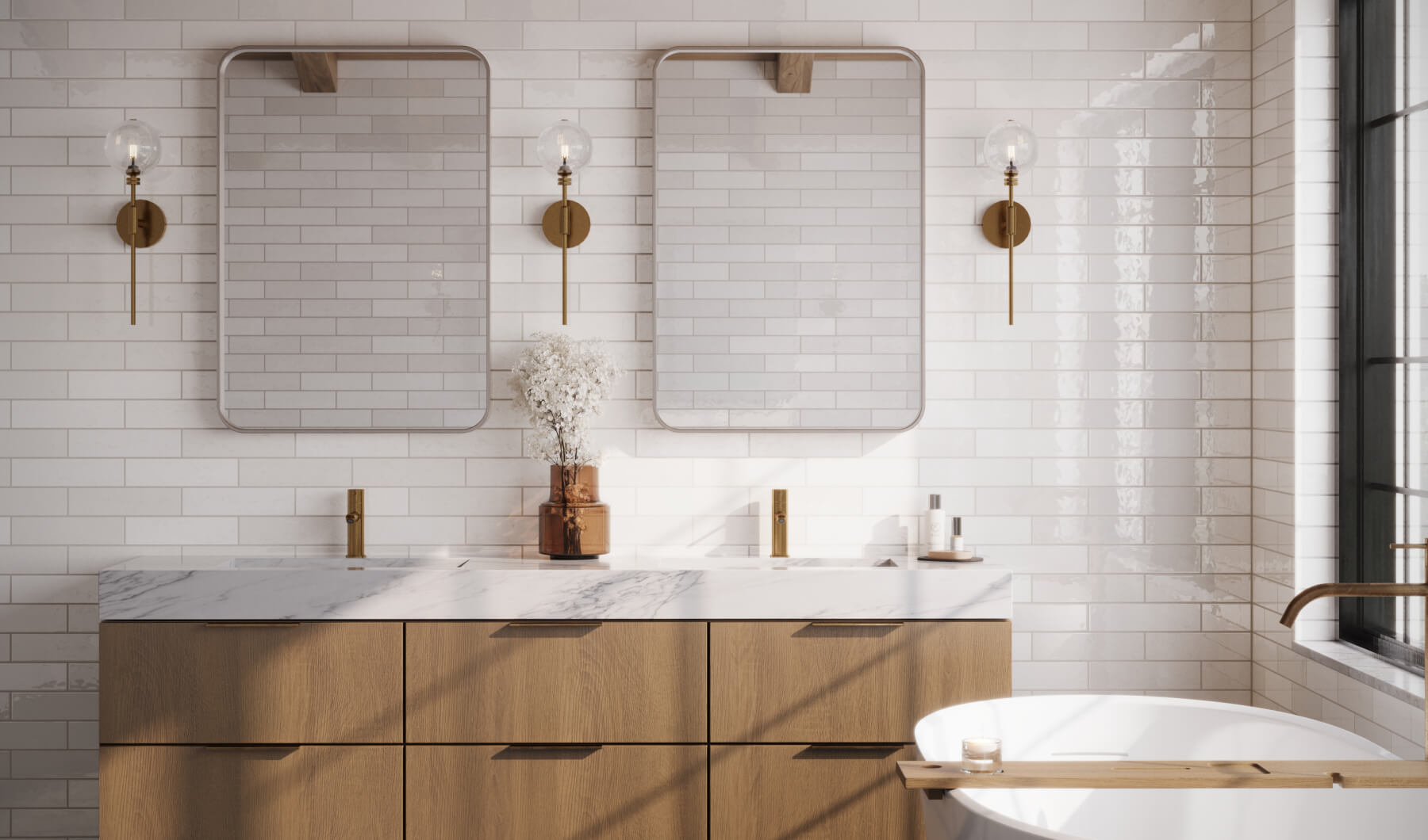 Elegant bathroom with glossy white subway tiles, a marble countertop, wooden vanity, dual mirrors, and brass fixtures