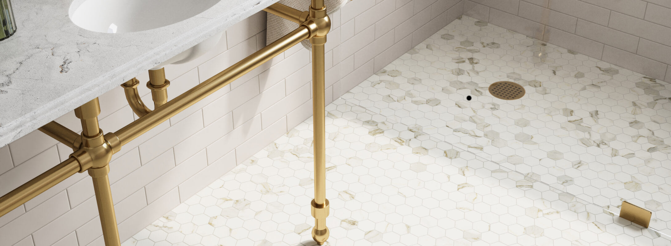 White marble look hexagonal mosaic tiles for a shower floor, paired with gold fixtures for a luxurious and elegant bathroom design