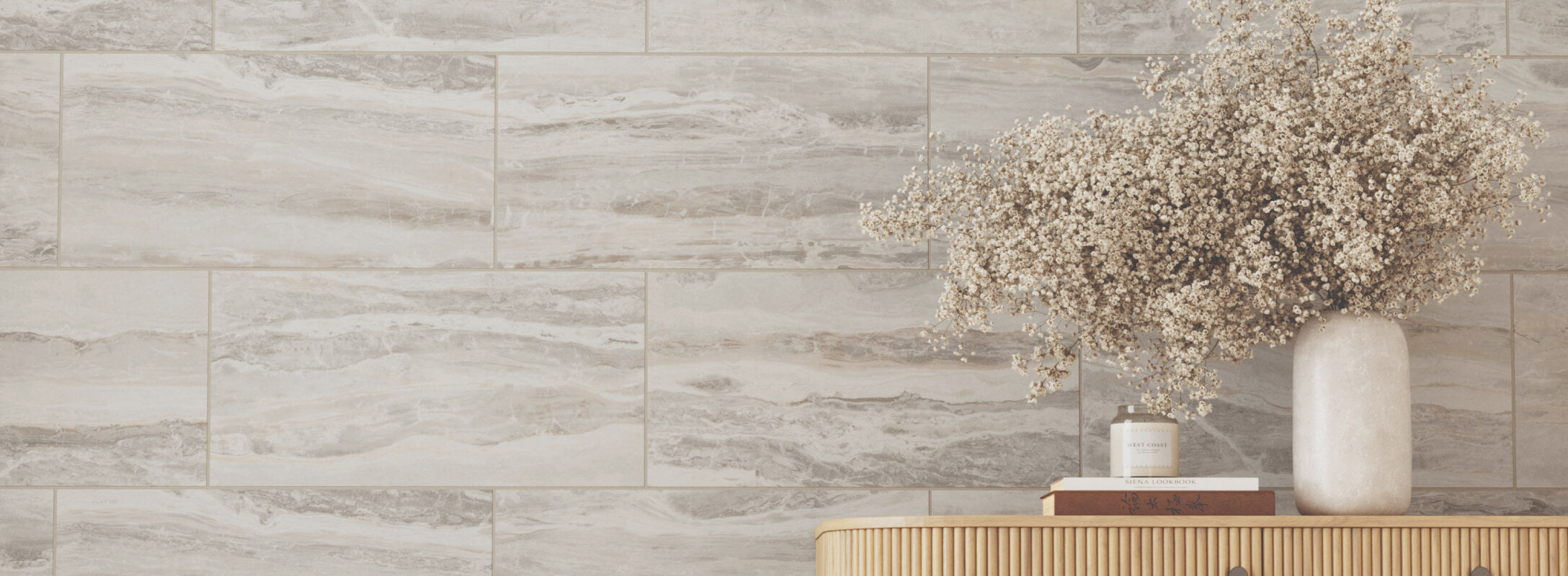 Elegant setting with taupe marble-look tiles, featuring a minimalist wooden table adorned with a vase of delicate white flowers