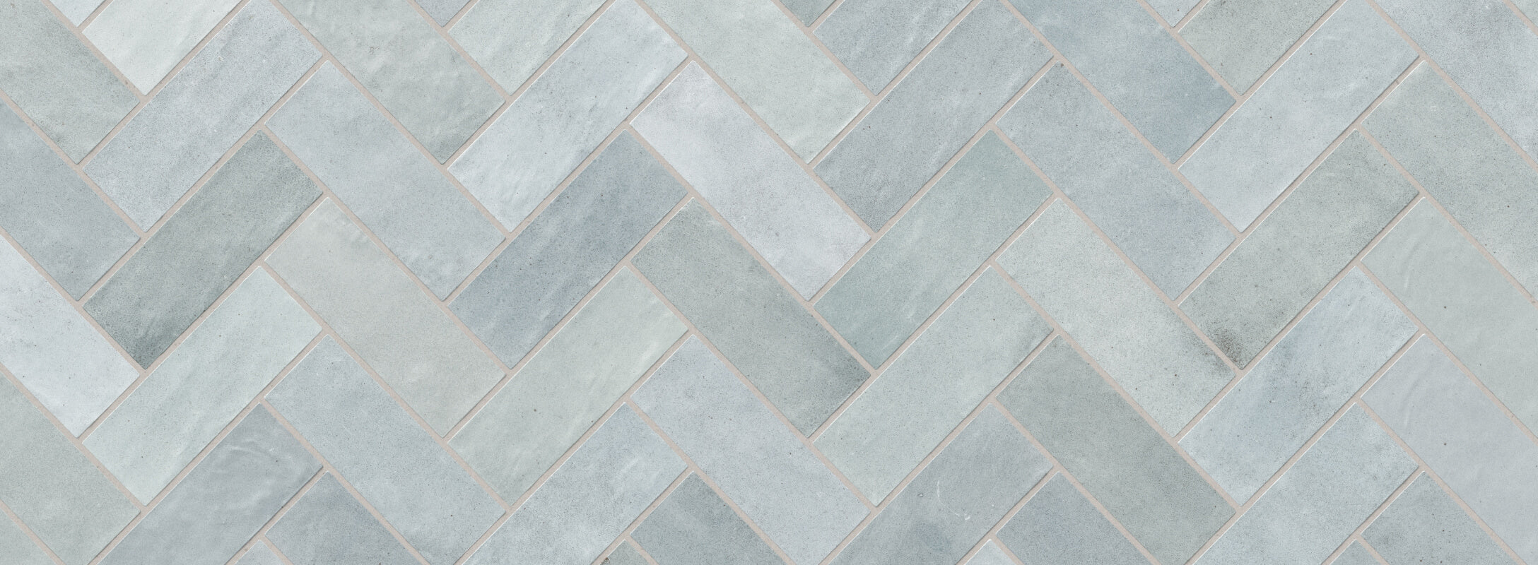 Soft blue herringbone tiles with a subtle texture, perfect for creating a calming and stylish kitchen backsplash