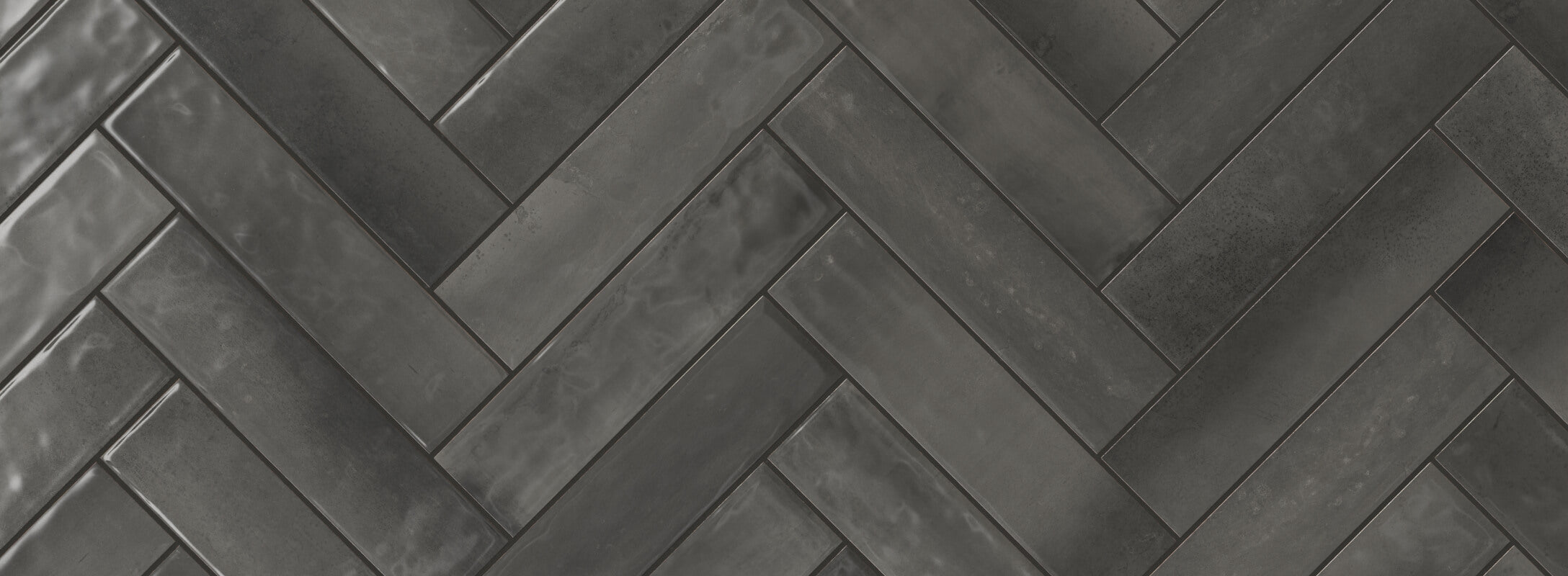Dark grey herringbone tiles with a sleek, glossy finish create a sophisticated and modern look, perfect for contemporary kitchen walls