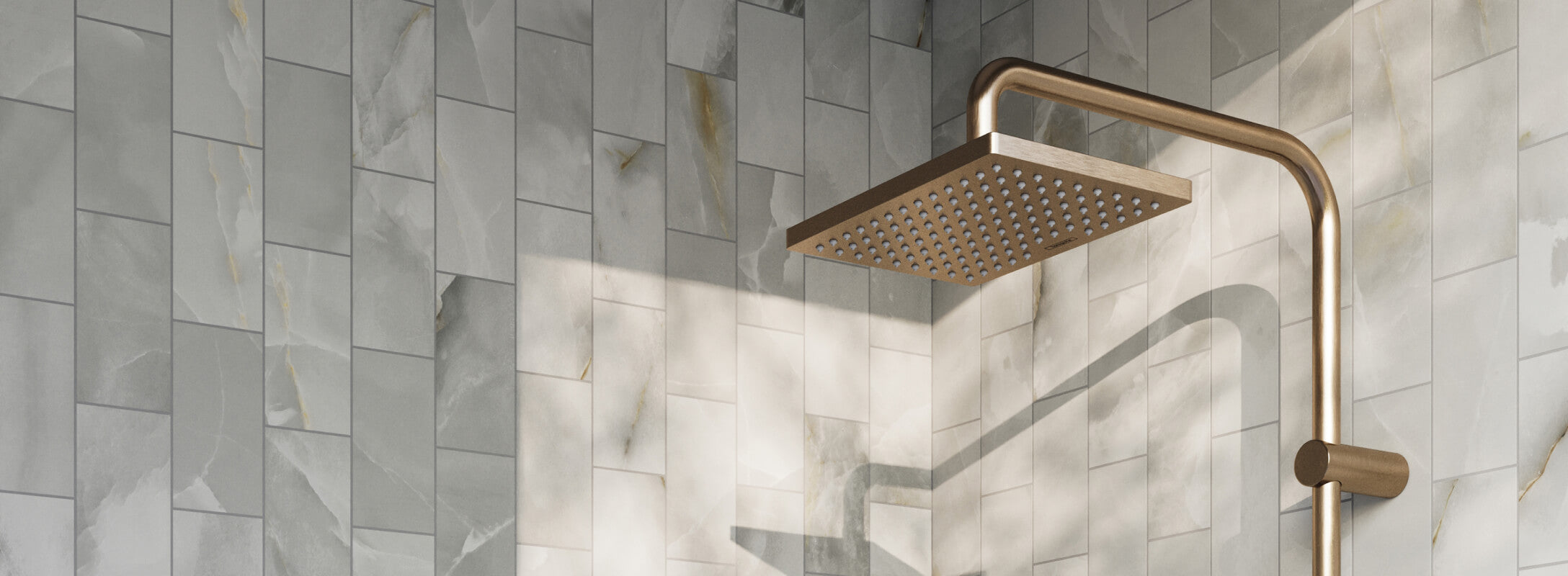 Luxurious shower featuring sleek grey marble-effect mosaic tiles and a brushed gold rain showerhead, creating a serene, spa-like atmosphere