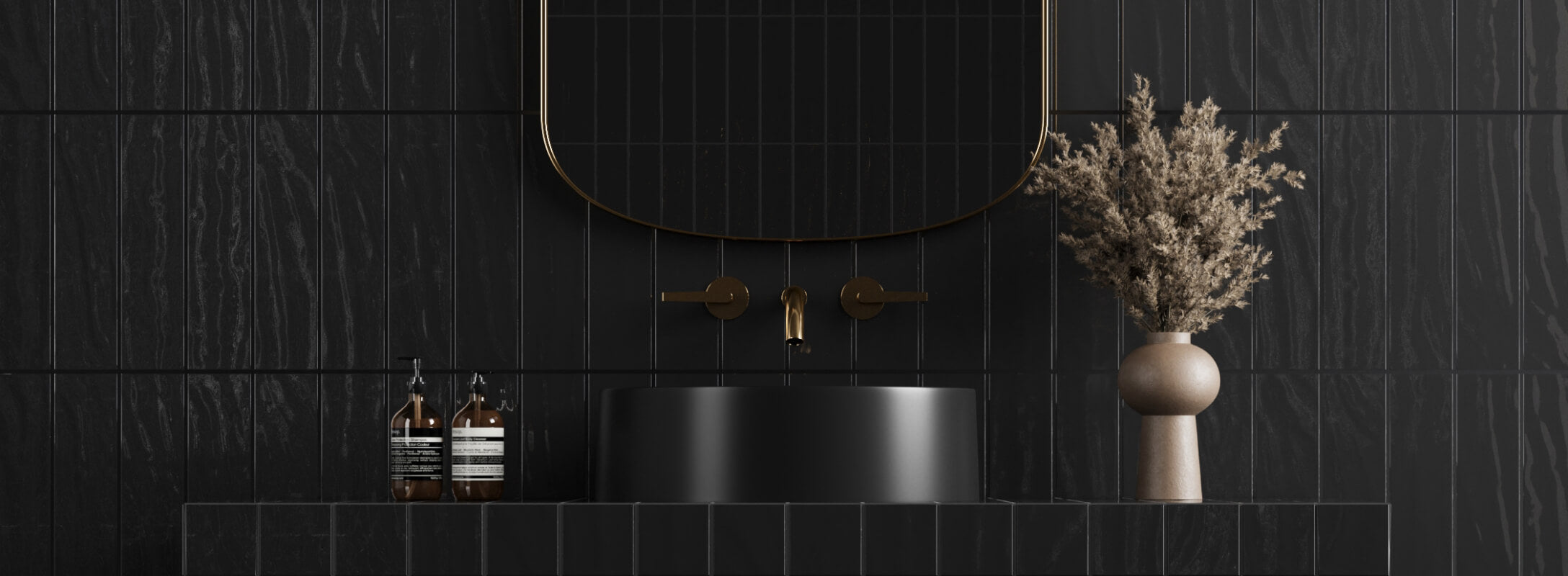 Elegant bathroom wall featuring textured black tiles, a matte black sink, brass faucets, and a minimalist vase with dried flowers