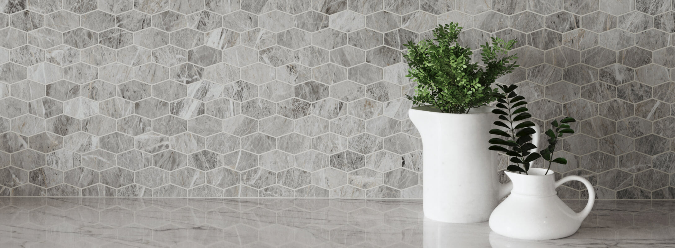 Hexagonal light grey tiles that look like marble create a modern, textured wall, complemented by white vases with greenery on a marble countertop